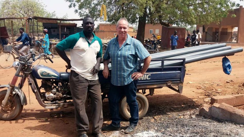 Auf Besorgungstour in Saaba: Thorsten Ehmann und Brunnenwart Doumia Dakyo transportieren Volanta-Ersatzteile.